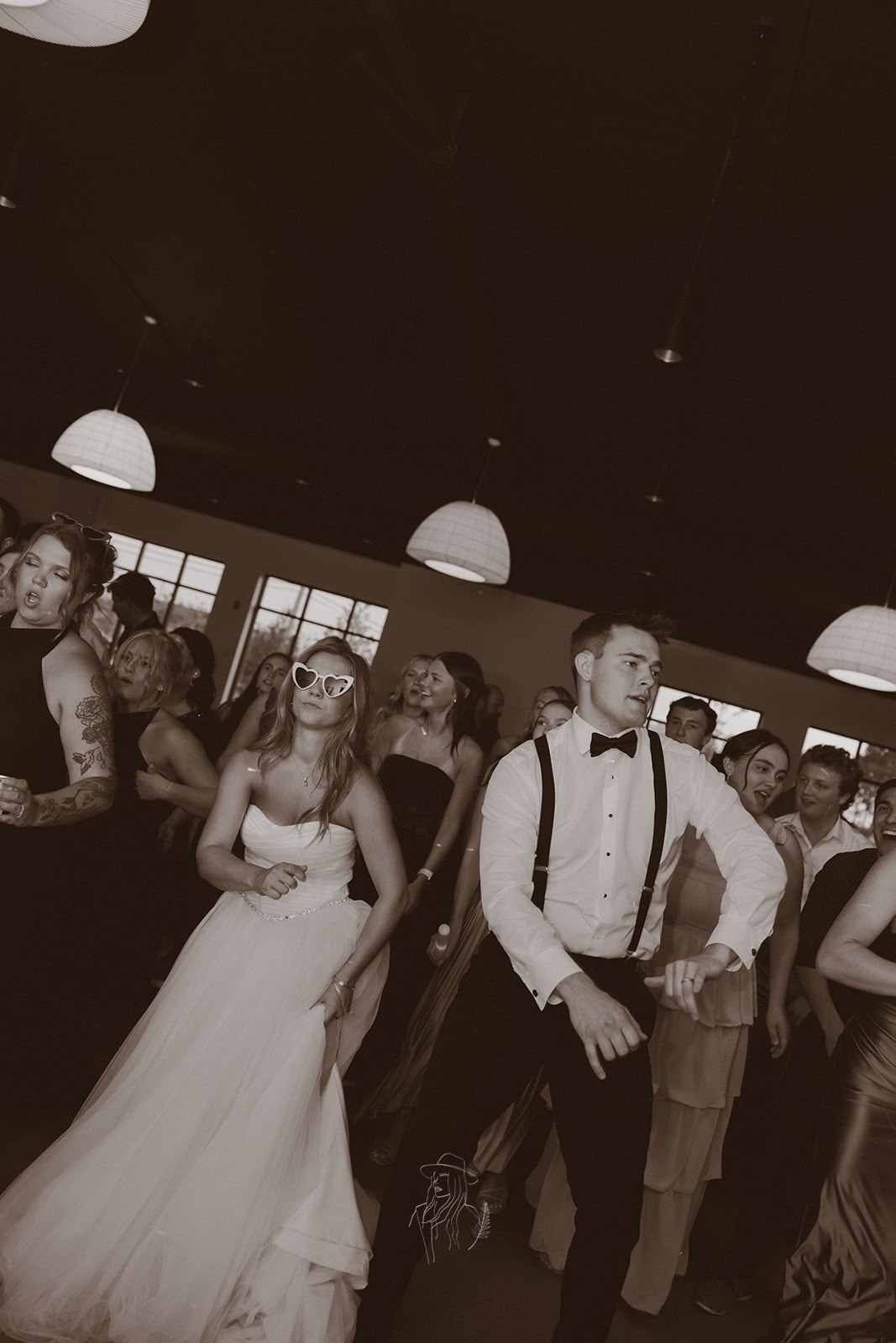 Bride and groom dancing with guests on the dance floor