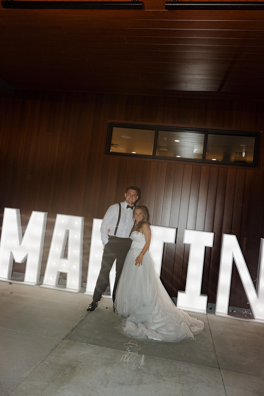Couple posing in front of illuminated marquee letters