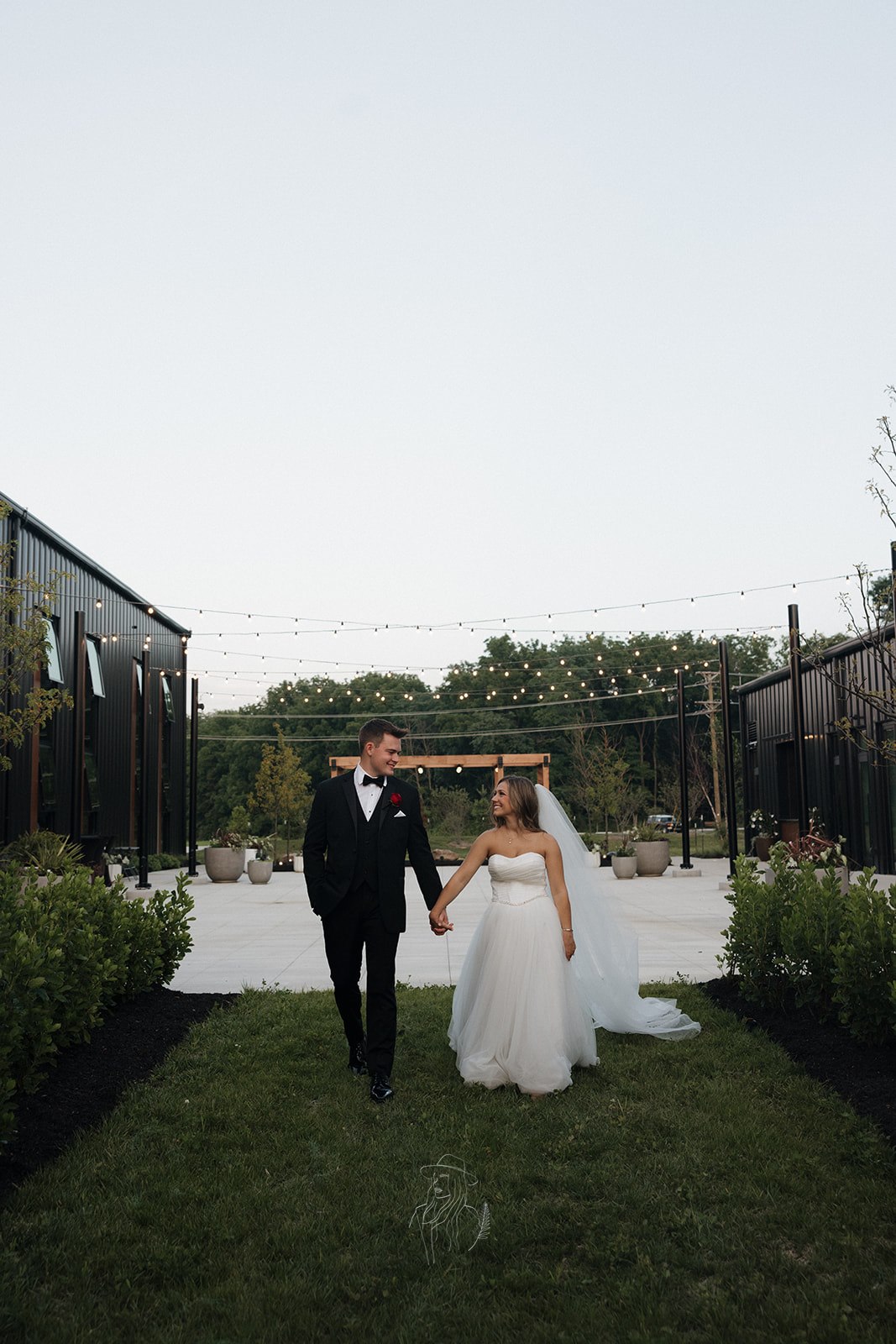 Couple strolling the courtyard under string lights at dusk