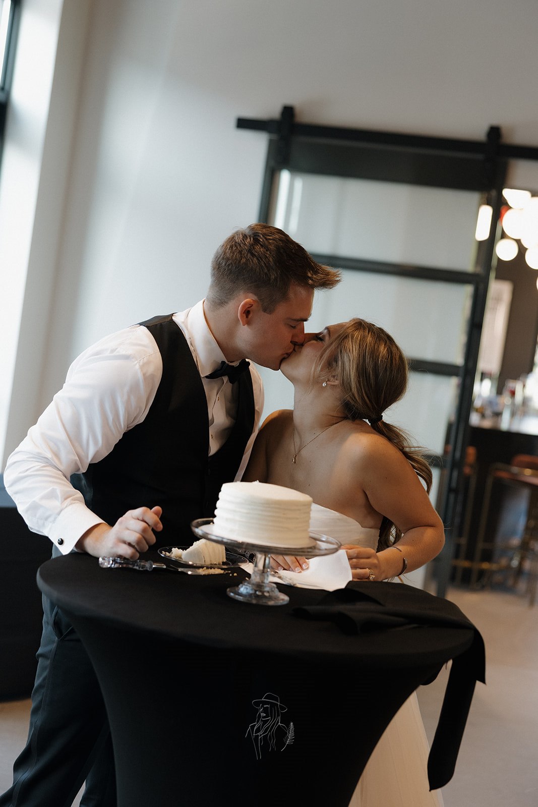 Bride and groom kissing after cutting the cake
