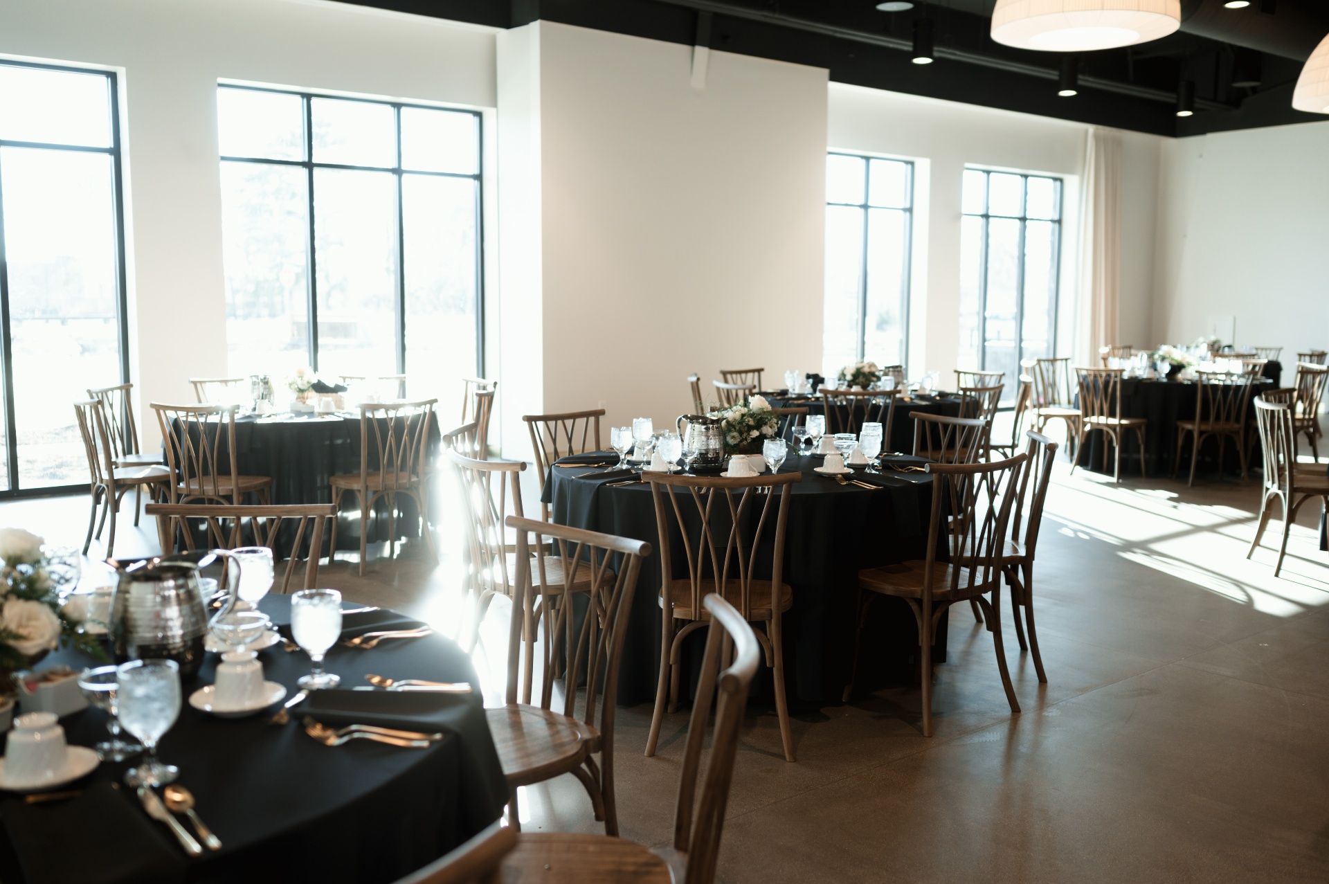 Reception hall set with round tables and crossback chairs