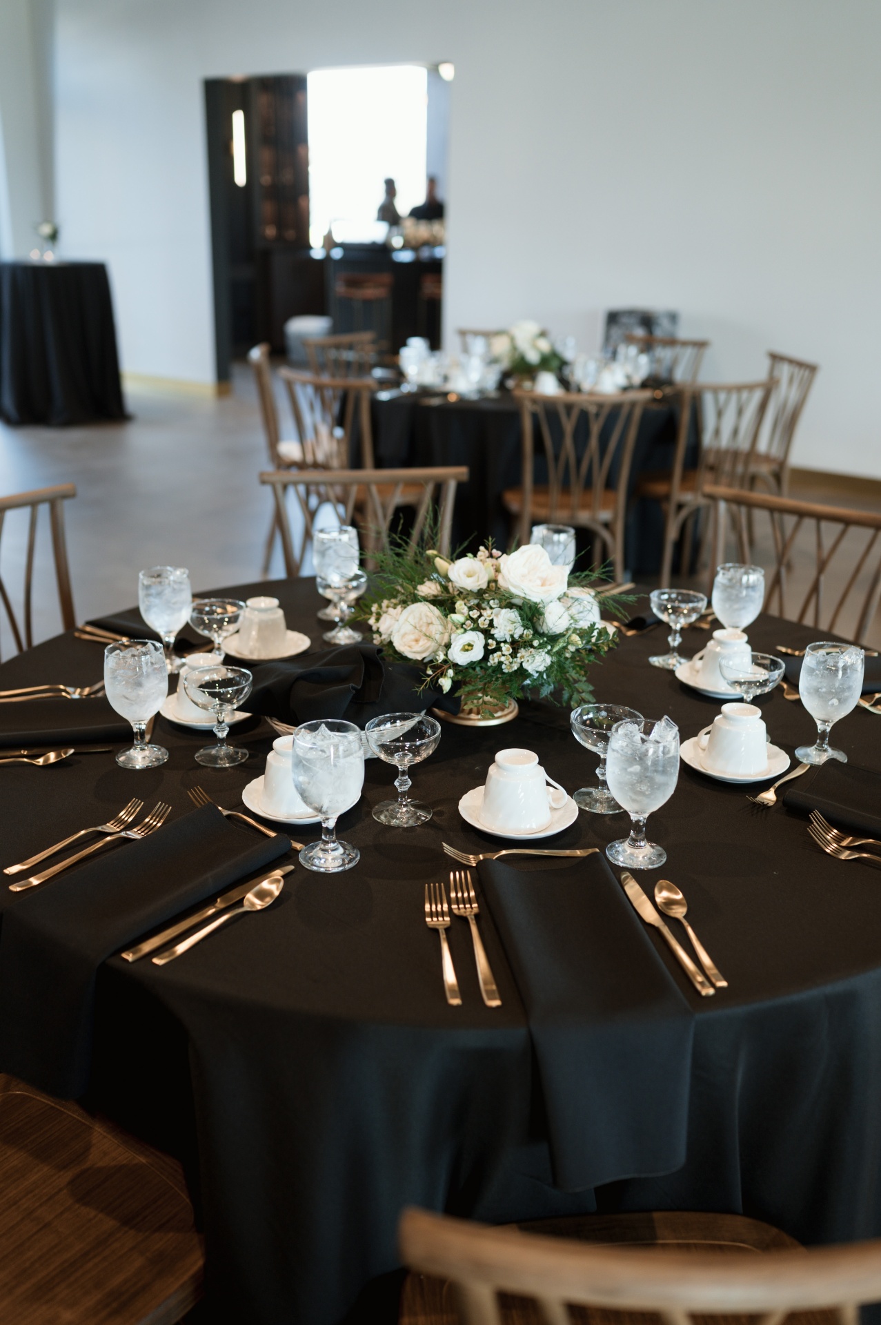 Reception table with black linens and gold flatware